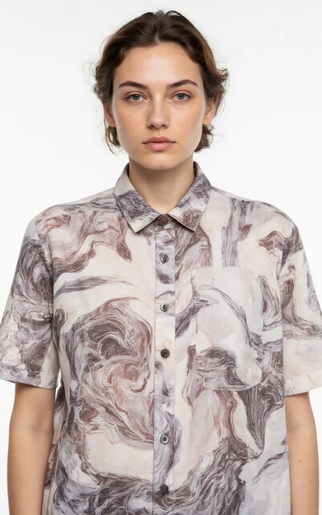 A French model wearing a Swirl pattern   printed shirt, against a white background, in a front   facing bust portrait